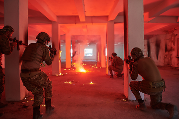 Image showing A group of professional soldiers bravely executes a dangerous rescue mission, surrounded by fire in a perilous building.