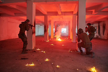 Image showing A group of professional soldiers bravely executes a dangerous rescue mission, surrounded by fire in a perilous building.