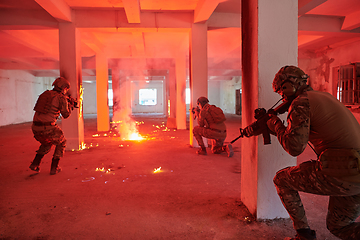 Image showing A group of professional soldiers bravely executes a dangerous rescue mission, surrounded by fire in a perilous building.