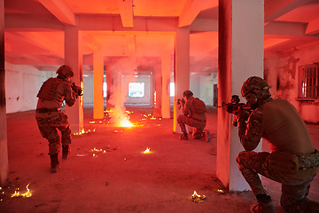 Image showing A group of professional soldiers bravely executes a dangerous rescue mission, surrounded by fire in a perilous building.