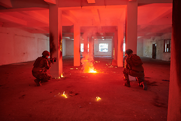 Image showing A group of professional soldiers bravely executes a dangerous rescue mission, surrounded by fire in a perilous building.