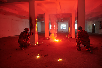 Image showing A group of professional soldiers bravely executes a dangerous rescue mission, surrounded by fire in a perilous building.