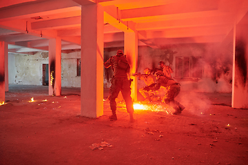 Image showing A group of professional soldiers bravely executes a dangerous rescue mission, surrounded by fire in a perilous building.