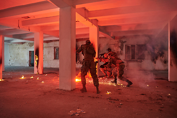 Image showing A group of professional soldiers bravely executes a dangerous rescue mission, surrounded by fire in a perilous building.