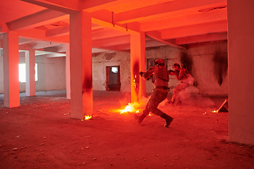 Image showing A group of professional soldiers bravely executes a dangerous rescue mission, surrounded by fire in a perilous building.