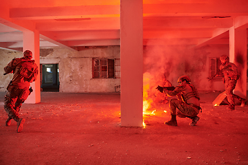 Image showing A group of professional soldiers bravely executes a dangerous rescue mission, surrounded by fire in a perilous building.