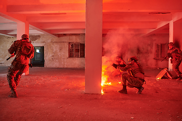 Image showing A group of professional soldiers bravely executes a dangerous rescue mission, surrounded by fire in a perilous building.