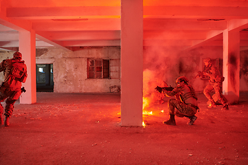 Image showing A group of professional soldiers bravely executes a dangerous rescue mission, surrounded by fire in a perilous building.