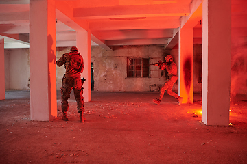 Image showing A group of professional soldiers bravely executes a dangerous rescue mission, surrounded by fire in a perilous building.