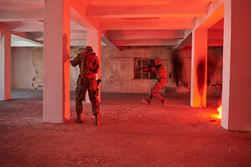 Image showing A group of professional soldiers bravely executes a dangerous rescue mission, surrounded by fire in a perilous building.