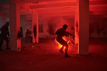 Image showing A group of professional soldiers bravely executes a dangerous rescue mission, surrounded by fire in a perilous building.