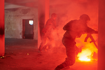 Image showing A group of professional soldiers bravely executes a dangerous rescue mission, surrounded by fire in a perilous building.