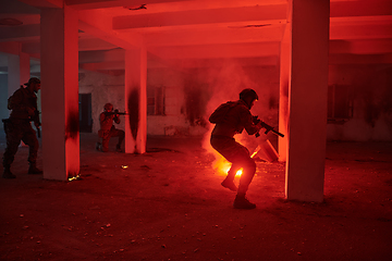 Image showing A group of professional soldiers bravely executes a dangerous rescue mission, surrounded by fire in a perilous building.