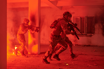 Image showing A group of professional soldiers bravely executes a dangerous rescue mission, surrounded by fire in a perilous building.