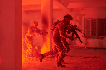 Image showing A group of professional soldiers bravely executes a dangerous rescue mission, surrounded by fire in a perilous building.