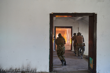 Image showing A group of professional soldiers bravely executes a dangerous rescue mission, surrounded by fire in a perilous building.