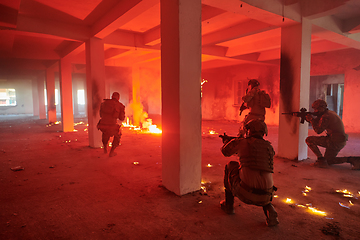 Image showing A group of professional soldiers bravely executes a dangerous rescue mission, surrounded by fire in a perilous building.