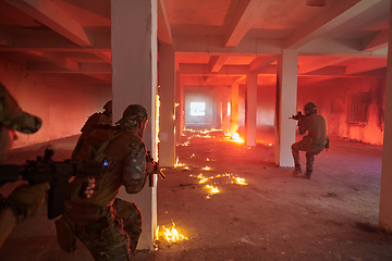 Image showing A group of professional soldiers bravely executes a dangerous rescue mission, surrounded by fire in a perilous building.