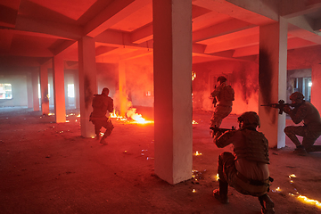 Image showing A group of professional soldiers bravely executes a dangerous rescue mission, surrounded by fire in a perilous building.