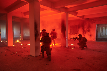 Image showing A group of professional soldiers bravely executes a dangerous rescue mission, surrounded by fire in a perilous building.