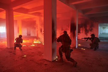 Image showing A group of professional soldiers bravely executes a dangerous rescue mission, surrounded by fire in a perilous building.