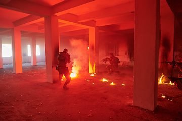 Image showing A group of professional soldiers bravely executes a dangerous rescue mission, surrounded by fire in a perilous building.