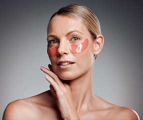 Image showing Beautiful mature woman posing with under eye patch in studio against a grey background