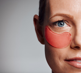 Image showing Beautiful mature woman posing with under eye patch in studio against a grey background