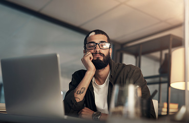 Image showing Are long working hours making me miss out on life. a young businessman looking uncertain while working late at night in a modern office.