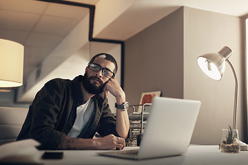 Image showing Focus flew right out the window. a young businessman looking uncertain while working late at night in a modern office.