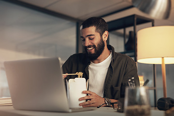 Image showing Working the late shift comes with some tasty perks. a young businessman having takeout and using a laptop during a late night at work.