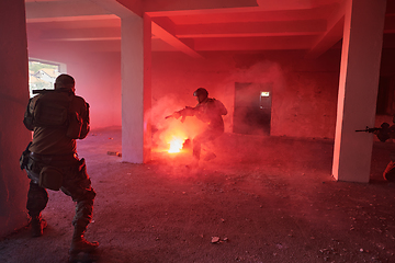 Image showing A group of professional soldiers bravely executes a dangerous rescue mission, surrounded by fire in a perilous building.