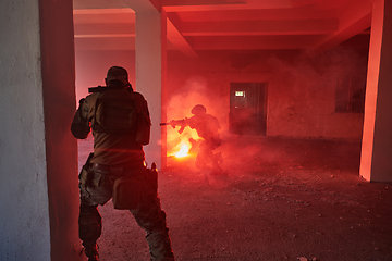 Image showing A group of professional soldiers bravely executes a dangerous rescue mission, surrounded by fire in a perilous building.