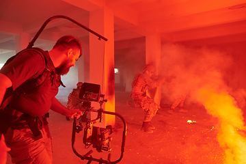 Image showing A professional cameraman captures the intense moments as a group of skilled soldiers embarks on a dangerous mission inside an abandoned building, their actions filled with suspense and bravery