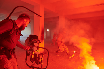 Image showing A professional cameraman captures the intense moments as a group of skilled soldiers embarks on a dangerous mission inside an abandoned building, their actions filled with suspense and bravery