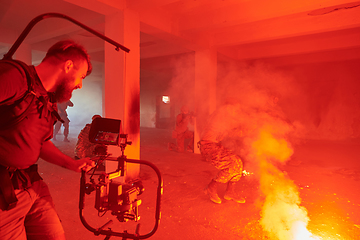 Image showing A professional cameraman captures the intense moments as a group of skilled soldiers embarks on a dangerous mission inside an abandoned building, their actions filled with suspense and bravery