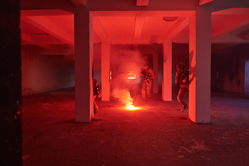 Image showing A group of professional soldiers bravely executes a dangerous rescue mission, surrounded by fire in a perilous building.