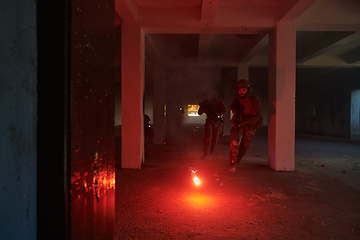 Image showing A group of professional soldiers bravely executes a dangerous rescue mission, surrounded by fire in a perilous building.