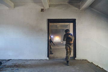 Image showing A group of professional soldiers bravely executes a dangerous rescue mission, surrounded by fire in a perilous building.