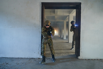 Image showing A group of professional soldiers bravely executes a dangerous rescue mission, surrounded by fire in a perilous building.