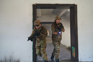 Image showing A group of professional soldiers bravely executes a dangerous rescue mission, surrounded by fire in a perilous building.