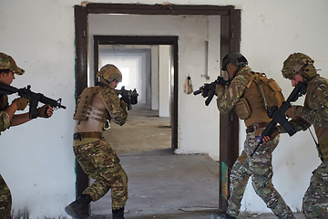 Image showing A group of professional soldiers bravely executes a dangerous rescue mission, surrounded by fire in a perilous building.