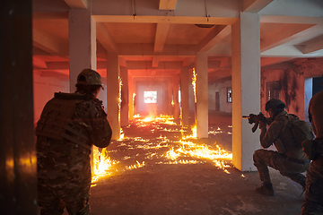 Image showing A group of professional soldiers bravely executes a dangerous rescue mission, surrounded by fire in a perilous building.