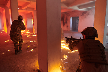 Image showing A group of professional soldiers bravely executes a dangerous rescue mission, surrounded by fire in a perilous building.