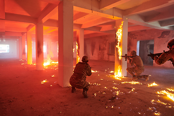 Image showing A group of professional soldiers bravely executes a dangerous rescue mission, surrounded by fire in a perilous building.