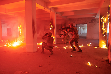 Image showing A group of professional soldiers bravely executes a dangerous rescue mission, surrounded by fire in a perilous building.