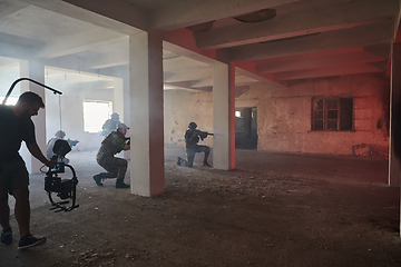 Image showing A professional cameraman captures the intense moments as a group of skilled soldiers embarks on a dangerous mission inside an abandoned building, their actions filled with suspense and bravery