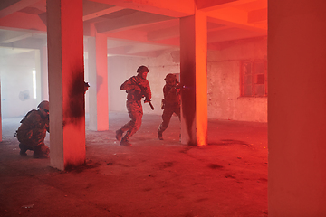 Image showing A group of professional soldiers bravely executes a dangerous rescue mission, surrounded by fire in a perilous building.