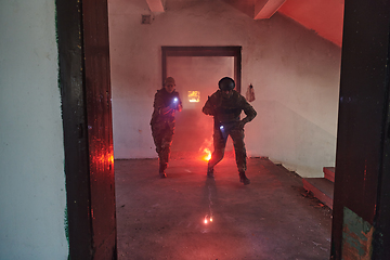 Image showing A group of professional soldiers bravely executes a dangerous rescue mission, surrounded by fire in a perilous building.