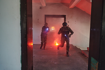 Image showing A group of professional soldiers bravely executes a dangerous rescue mission, surrounded by fire in a perilous building.